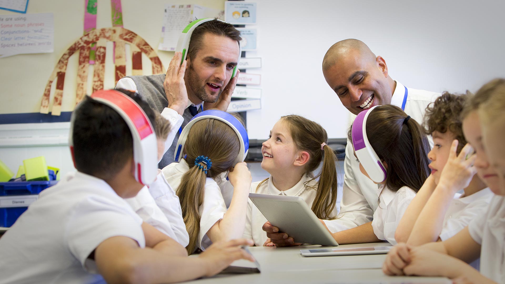 Teachers using technology with grade school students