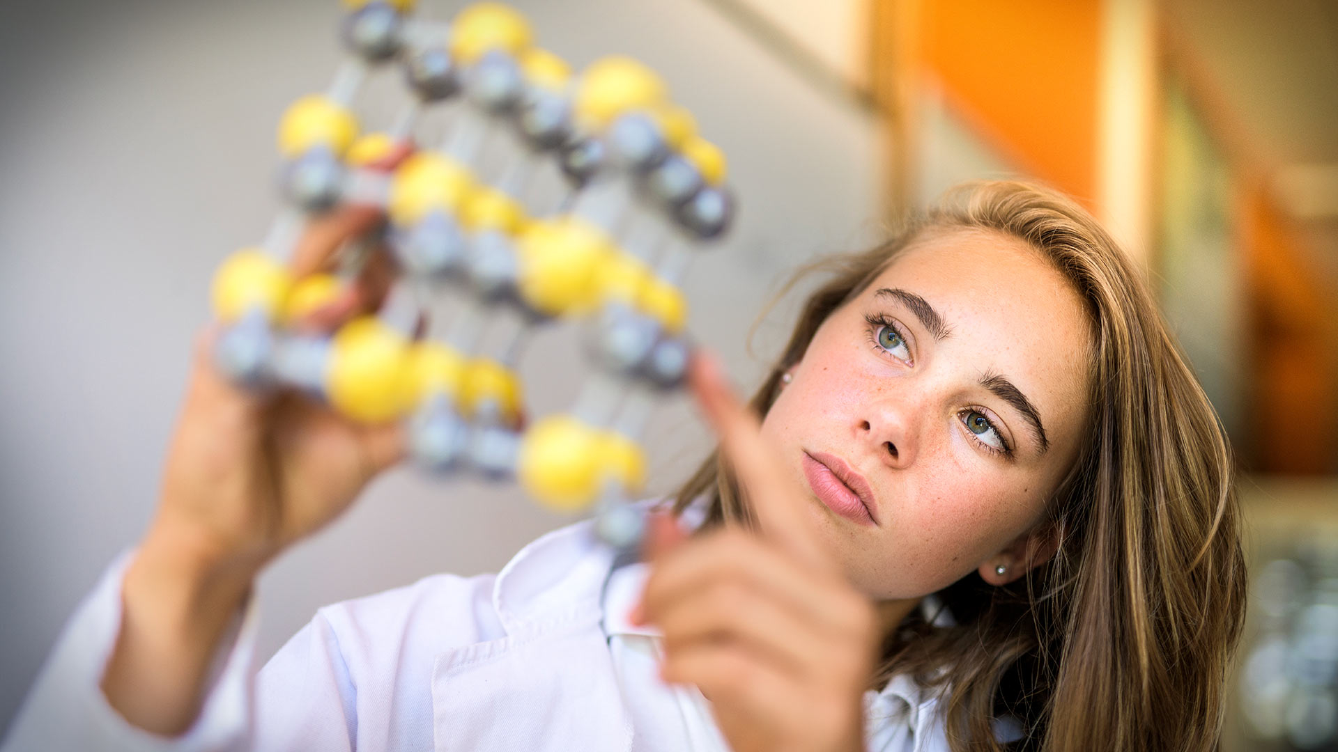 Student examining a molecule model