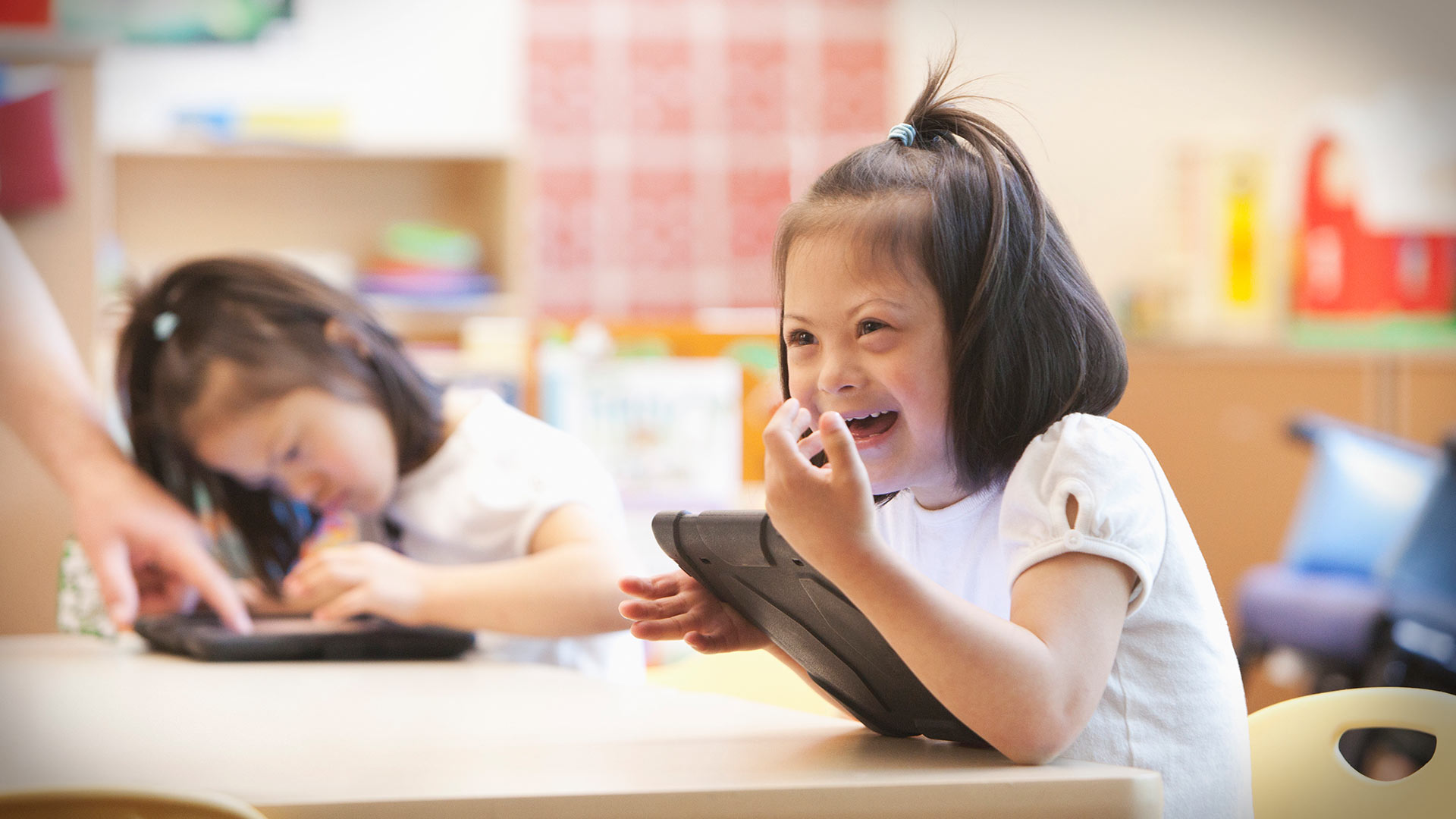 Child laughing sitting at desk