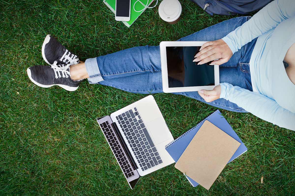 Student on laptop in grass